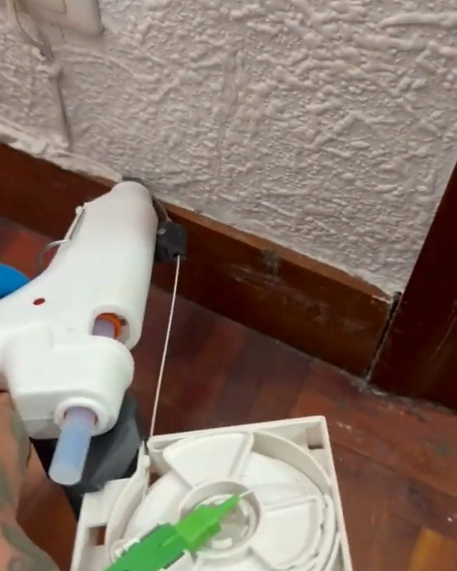 Pegando la fibra al rodapié con la herramienta termofusible